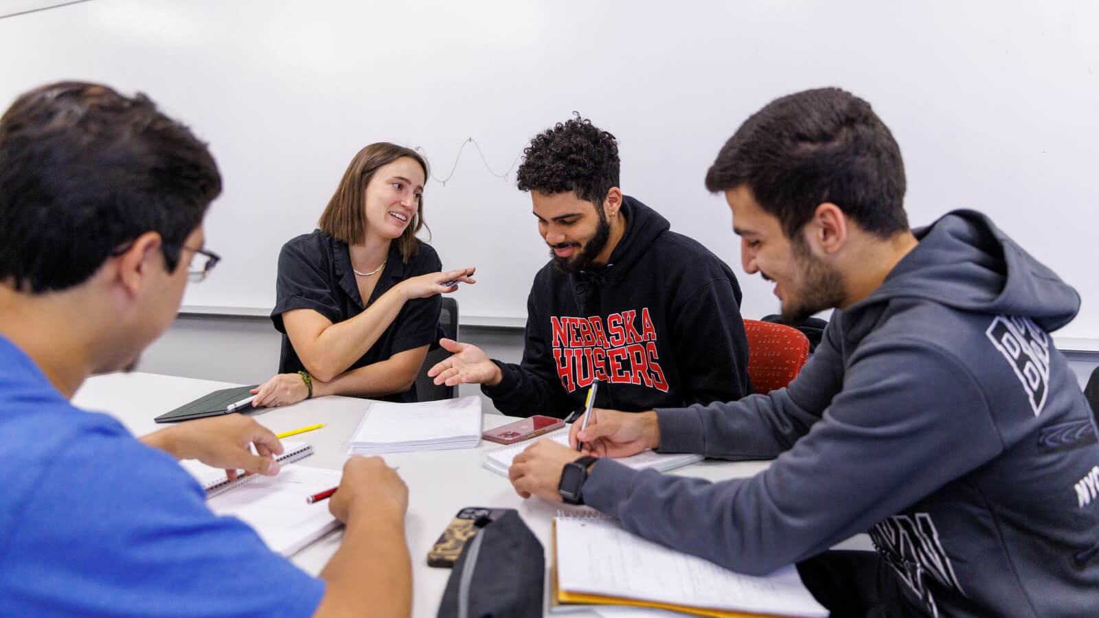 Students sitting at table working on homework.